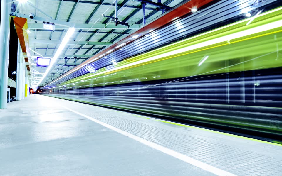 Train passing a station platform in a blur of light